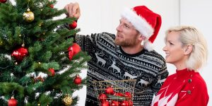 Žena s mužom vešajú ozdoby na vianočný stromček