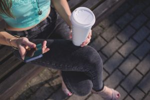 kava v ruke a mobil zena